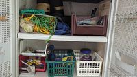 Overall view of shelves with assorted tools, ropes, baskets, and containers.