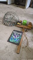 Wire wall/fence flower baskets (round and half-oval), hand painted slate art with floral Welcome design, wooden garden stake with saying, boxed solar light, small metal bell on garage floor