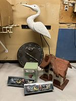 Overview photo showing all items together: wooden birdhouse, white wooden bird statue, ceramic bird clock, mini salt and pepper sets in packaging, and the bird bath ornament.