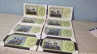 Eight graduation photo frames still in original packaging with white and black colors, shown stacked and laid out.