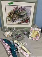 Full lot arranged on table showing framed print, handpainted glass items, card, and hangers