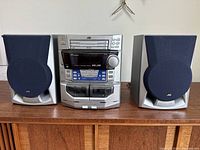 Front side view of JVC MX-J30 stereo component system between two JVC speakers on wooden surface.