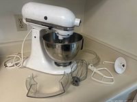 Overview of mixer on countertop with bowl and attachments spread around