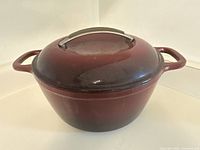 Burgundy round Dutch oven with lid, showing overall condition and color.