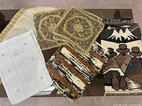 Table surface showing all linens: gold runner, white placemats with stars, gold embroidered doilies, woven placemats, and Nauvihou runner.