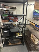 Black metal shelving unit with various items removed, showing shelf dimensions labeled.