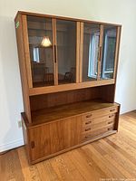 Front view of full two-piece hutch cabinet showing glass doors on top and drawers on base