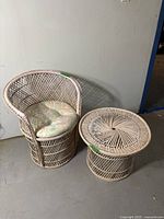 Pink wicker barrel chair and matching side table captured together showing overall condition and size.