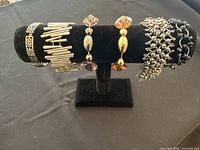 Photo showing six assorted fashion bracelets arranged on a black jewelry display stand.