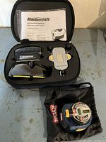Photo of Mastercraft Hawkeye Laser Level including operating manual, carrying case, and mounting accessories, with Ryobi laser level bag visible