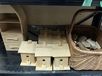 Photo of unfinished wooden birdhouses, showing multiple units with round entrance holes and small steps.