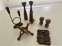 The full lot arranged on a white surface showing all wooden decorative items including candle holders, wooden animal figurines, a wooden puzzle, and a carved plaque.