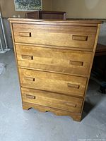 Full view of the 4 drawer wooden dresser, showing front, drawers, handles, and overall condition.