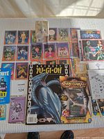 Full view of assortment showing Bandai cards, Yu-Gi-Oh Beckett magazine, Fortnite cards, Redakai card pack, and Ultraman pencil holder boxed figure.