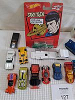 Closer photo of assorted Matchbox, Hot Wheels and other toy cars including Star Trek Hot Wheels car close up
