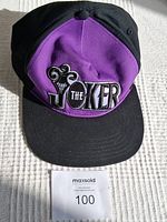 Front view of the DC Batman The Joker baseball cap showing purple front panels with black brim and sides, embroidered Joker logo.