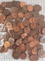 Close-up image of multiple Canadian pennies showing copper color and maple leaf designs with some wear.