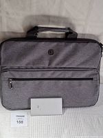 Grey fabric computer case with front zippered pocket and handles, showing entire case with portable charger in front.