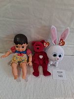 Full view of all three items: Disney Snow White baby doll, red Beanie Bear, and white Beanie Rabbit plush toys with Ty tags.