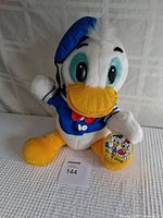 Front-right angle view of vintage Donald Duck plush puppet, vivid colors and original Disney tag visible.
