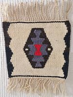 Top view of mini rug showing entire 11"x8" rectangular Kilim pattern with fringe and overall color.