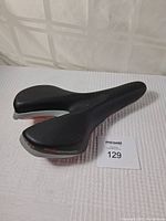 Full view of specialized gel bicycle seat showing black color, aerodynamic shape, and seat rails