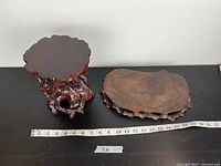 Both plant stands displayed on black surface with measuring tape showing width.