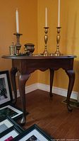 Full view of wood accent table with curved legs and decorative apron, showing items placed on top (not included).