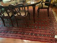 Overall view of red area rug under dining table and chairs