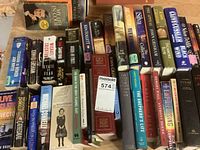 Photo of fiction books laid flat, showing titles and conditions for identification.