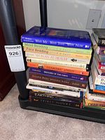 Stack of 13 assorted books including spirituality and wellness titles in good used condition on a black metal shelf.