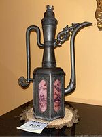 Full view of the vintage Chinese pewter teapot from front angle showing handle, spout, and overall shape.