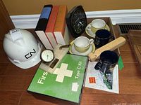 Lot of Canadian National Railway collectibles including hard hat, clocks, mugs, tile, first aid kit, books, and stapler.