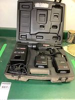 Full case opened showing cordless drill, two batteries, charger, and molded plastic carrying case.
