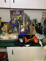 View of cordless drill, hardware bins, and assorted hardware items on counter