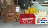 Wooden Canadian Butter Co-op crate along with Coca-Cola, Pepsi, and Money Back bottle carriers arranged on a basement floor