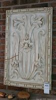 Front view of the daffodil relief resin panel mounted on a brick wall, showing the full design and frame.