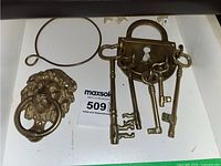 Top view showing the brass lion head door knocker ring and padlock-shaped holder with skeleton keys.