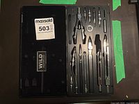 Set inside black molded case showing various compasses, dividers and accessories from top view