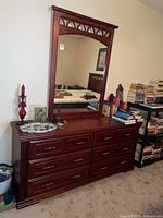 Wide photo of six drawer dresser with large framed mirror on top, showing wood finish and design details.