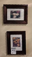 Framed floral prints hanging on wall showing both frames, one above the other.