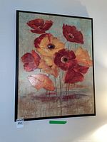 Framed print of red and orange poppies with a painterly texture in a black frame.