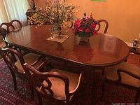 Full view of dining table set in room with two leaves installed, chairs visible but sold separately.