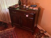 Front view showing single drawer and double-door cabinet with brass hardware