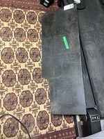 Granite slab laying on patterned carpet, showing the top surface and irregular edges.