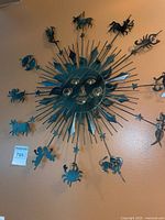 Full view of the metal sun wall art featuring zodiac symbols around a sun face center.