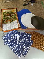 Image showing various placemats and a wall hanging calendar with a sunny outdoor scene and people, plus some brown bead placemats.