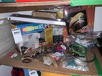 Wide view showing projector on wooden shelf with craft supplies, art books and boxed projector