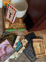 Photo showing assorted runes in two sets, multiple satin pouches, and oracle and rune related books.