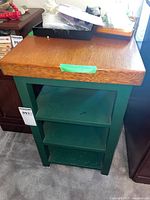 Front view of the wood top green shelf with items placed on top